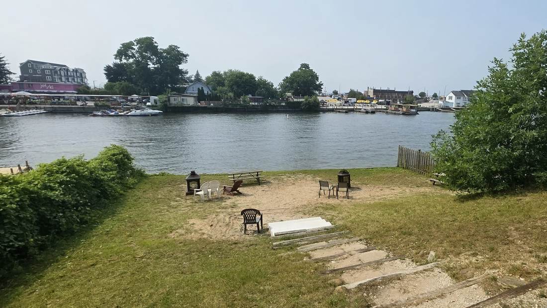 Waterfront Wasaga Beach property where lawn runs down to sand at the river's edge