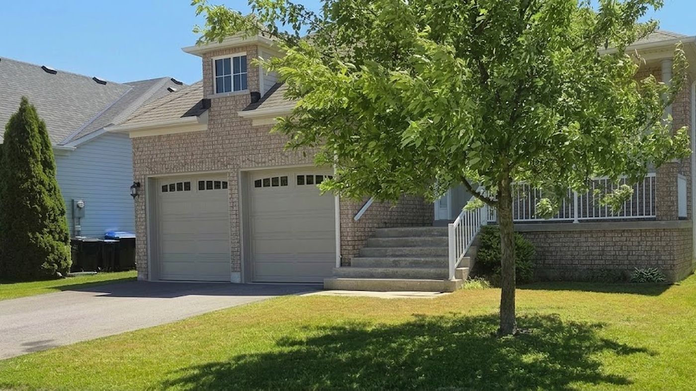 Front lawn cut around a mature shade tree at a Wasaga Beach home